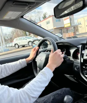 Over-the-shoulder view of a learner steering through a turn