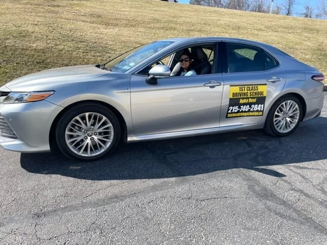 Instructor at the wheel of the silver dual-control training car
