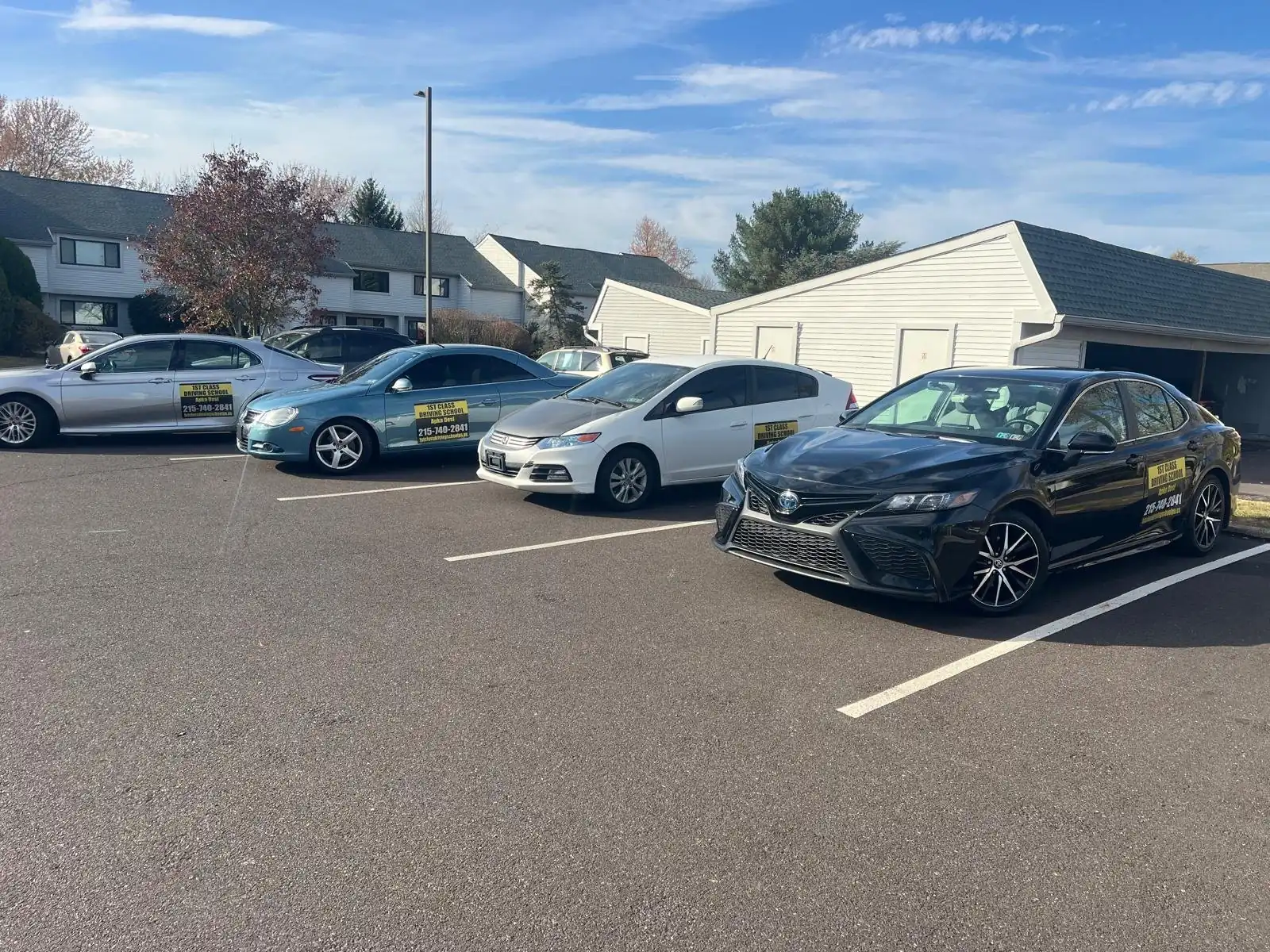 Driving-school cars lined up in a parking lot used for parking practice