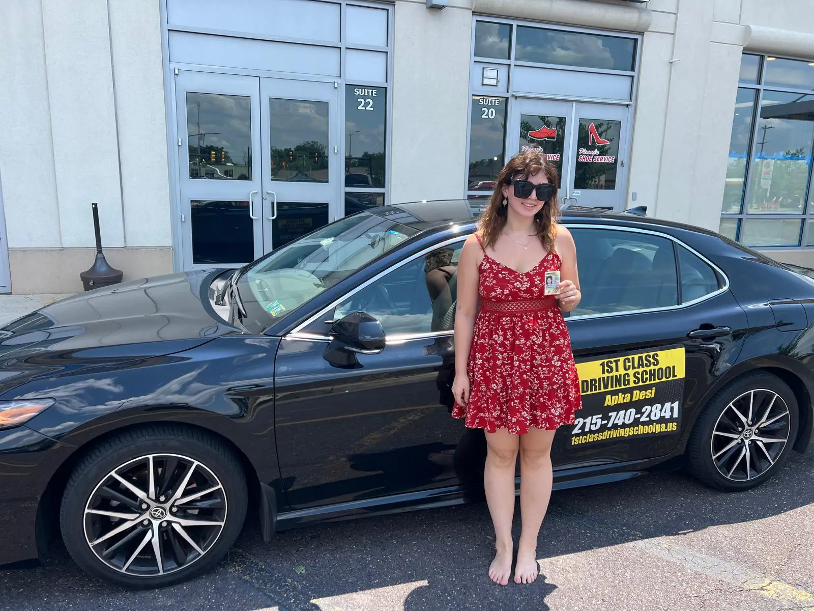 Student standing beside the training car outside a driver license center