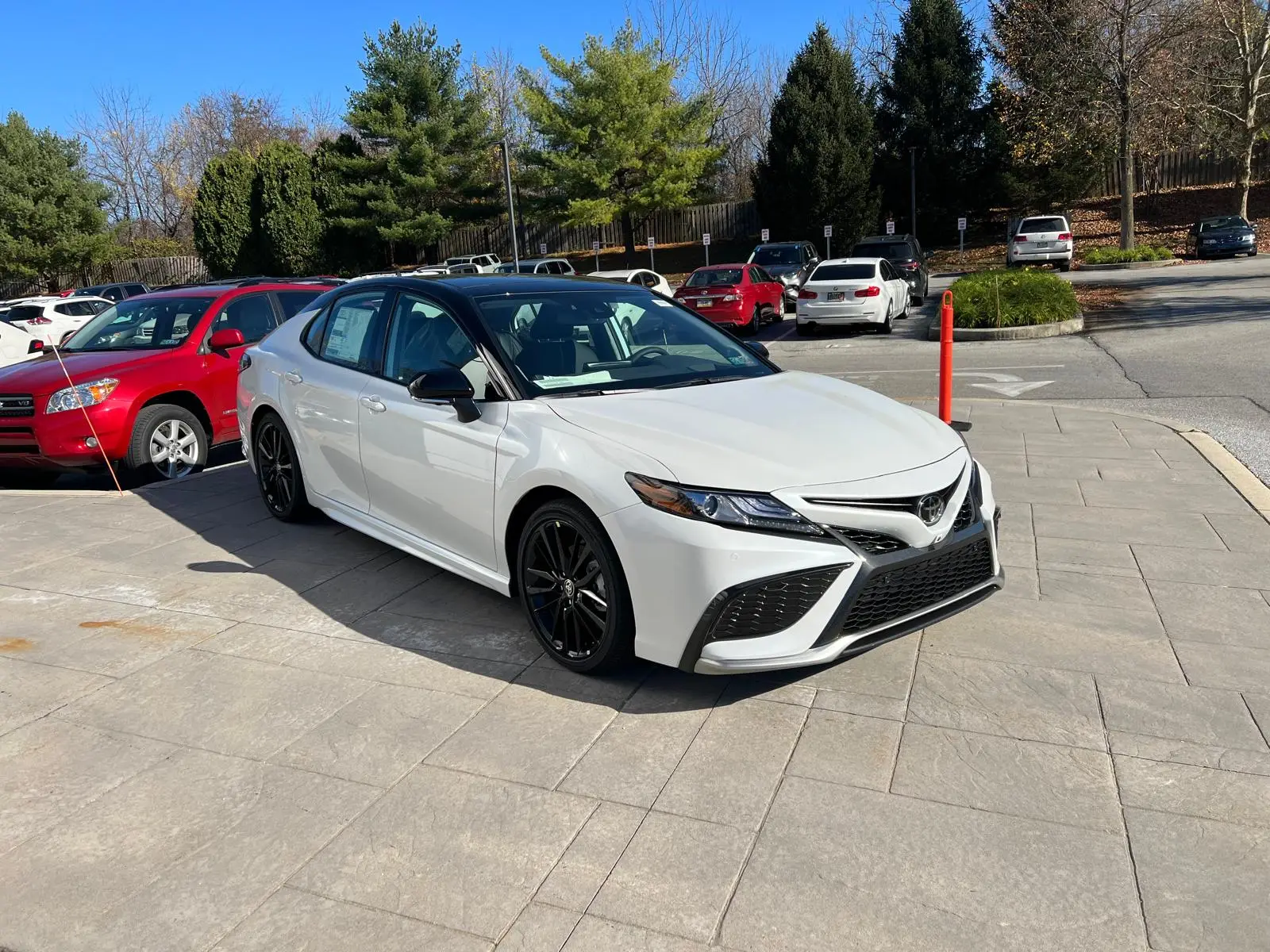 White training car parked among traffic on a clear day