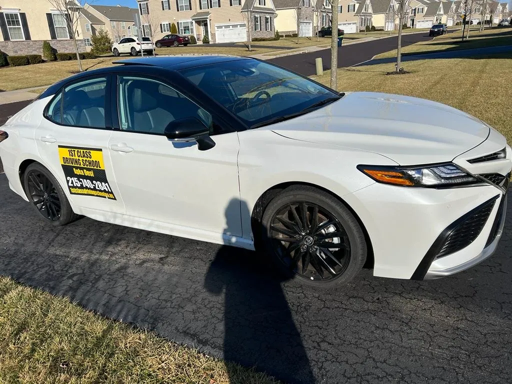 White Toyota Camry driving-school car on a suburban Pennsylvania road
